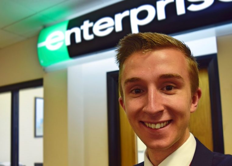 Selfie of James in front of Enterprise sign
