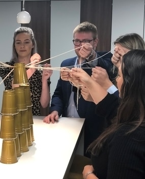 Employees doing a team building activity with gold solo cups