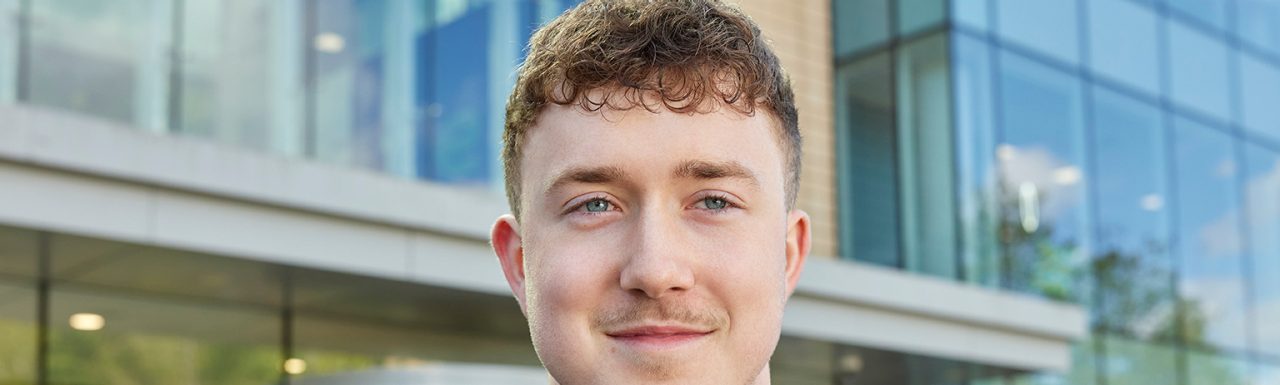 Enterprise Mobility Business Administration Apprentice standing outside a head office. 