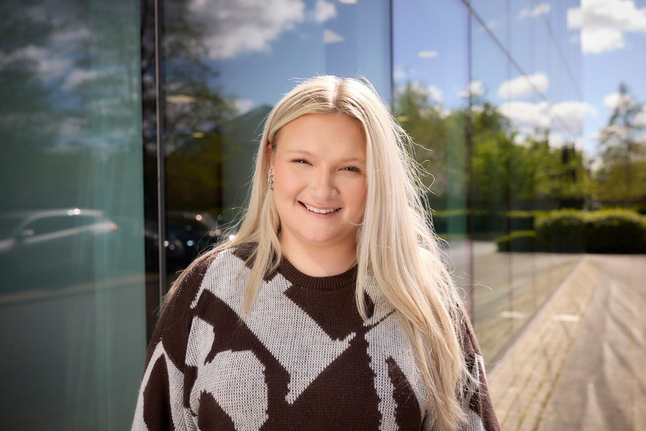 Enterprise Mobility Business Administration Apprentice smiling and standing outside a head office. 