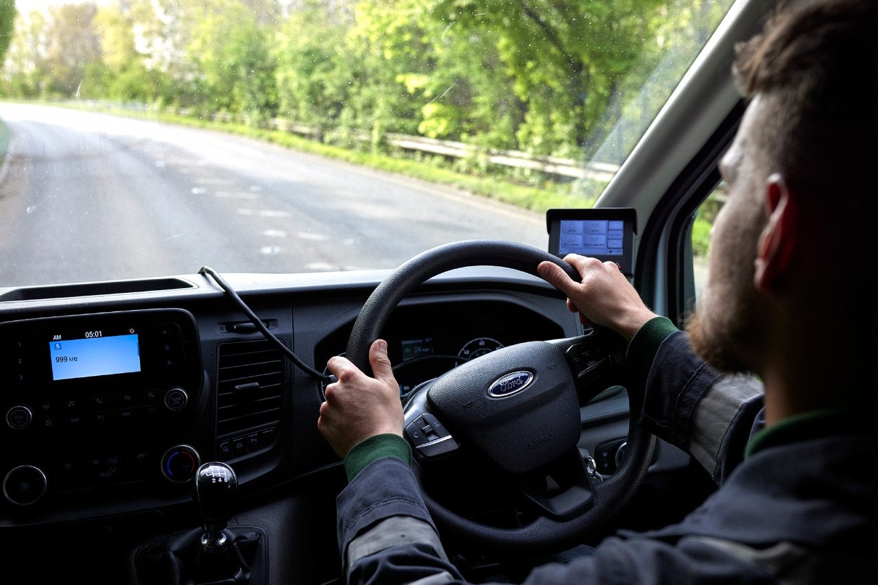 Enterprise Mobility team member driving a vehicle along a country road.