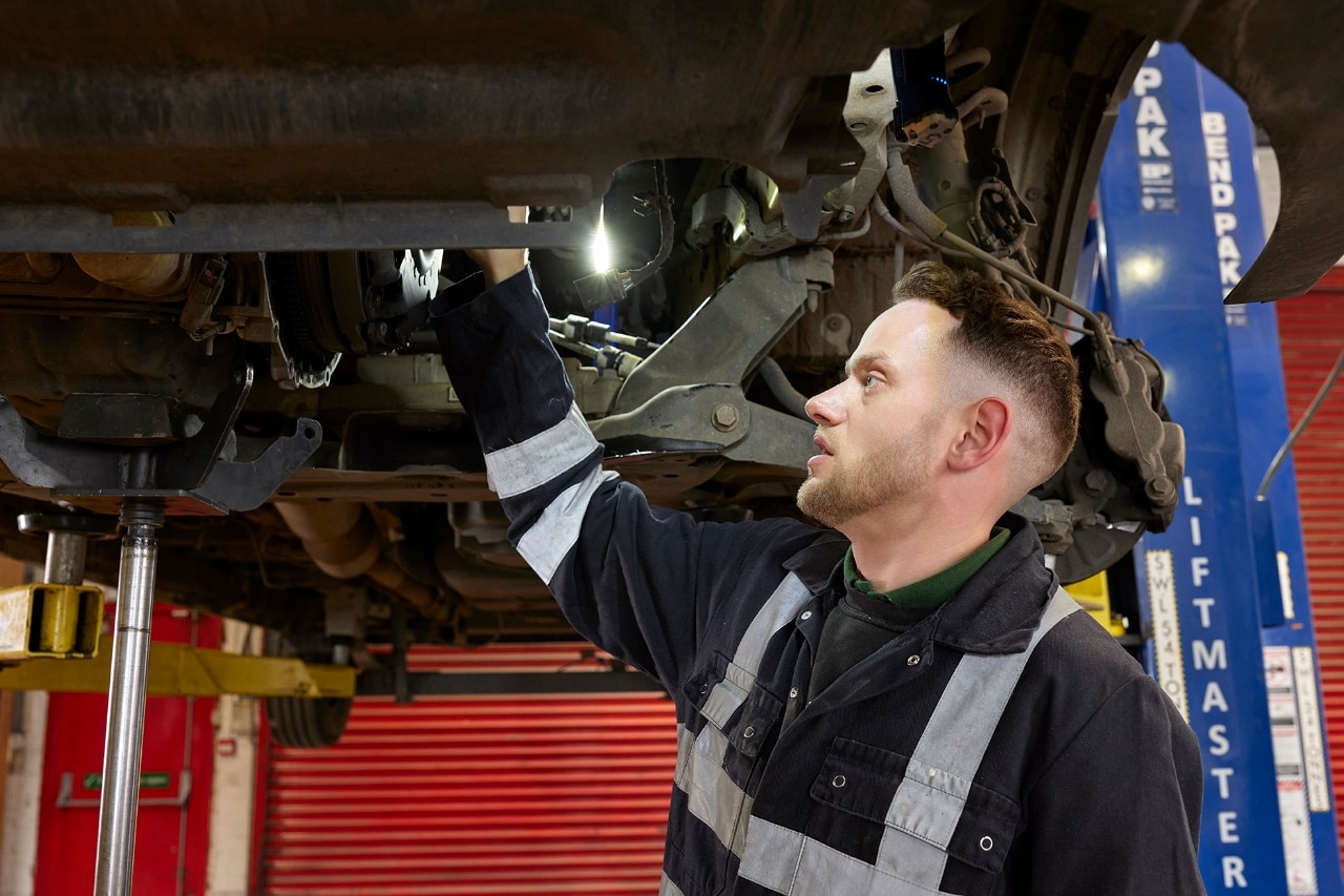 Enterprise Mobility Mechanic standing in a car and truck repair workshop.  