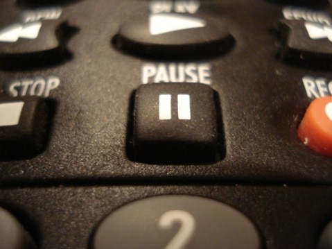 TV remote focused on the "pause" button