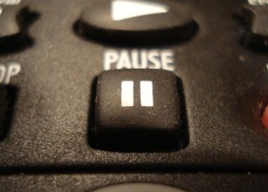 TV remote focused on the "pause" button