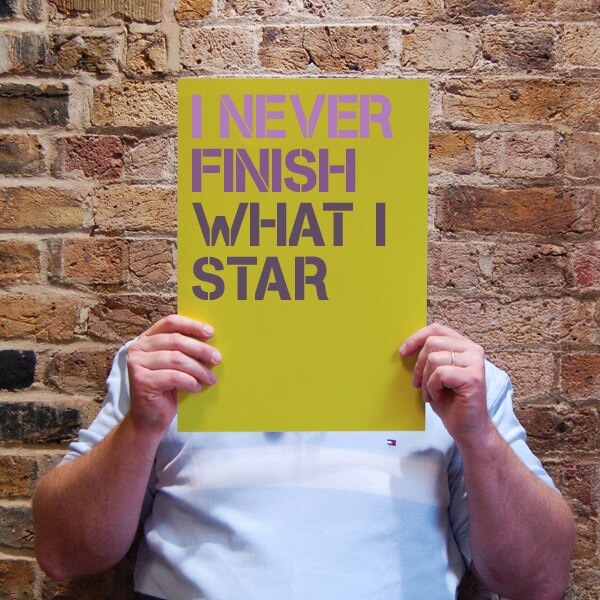 Man holding sign about procrastination that reads "I never finish what I star"
