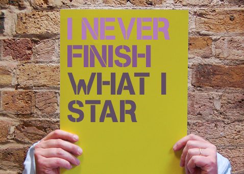 Man holding sign about procrastination that reads "I never finish what I star"