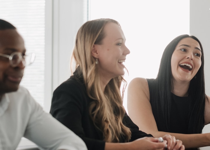 Interns sitting at a conference table while talking and laughing
