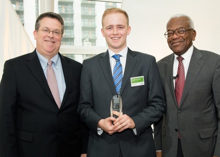 George Fisher-Wilson receiving an award from two men