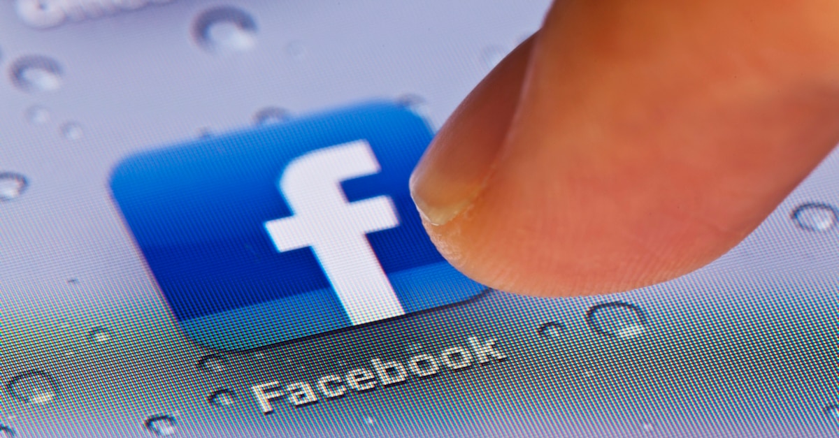 Finger pressing Facebook app icon
