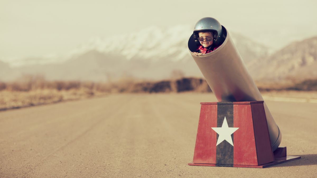 Little boy with helmet and sunglasses ready to be launched like a rocket