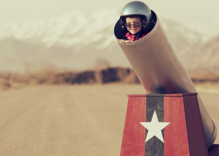 Little boy with helmet and sunglasses ready to be launched like a rocket