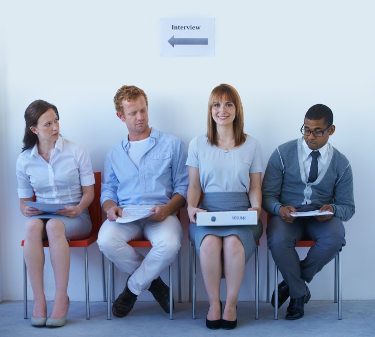 Four people waiting in chairs for an interview