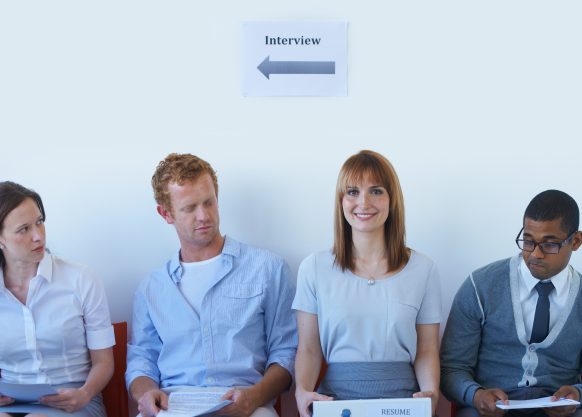 Four people waiting in chairs for an interview