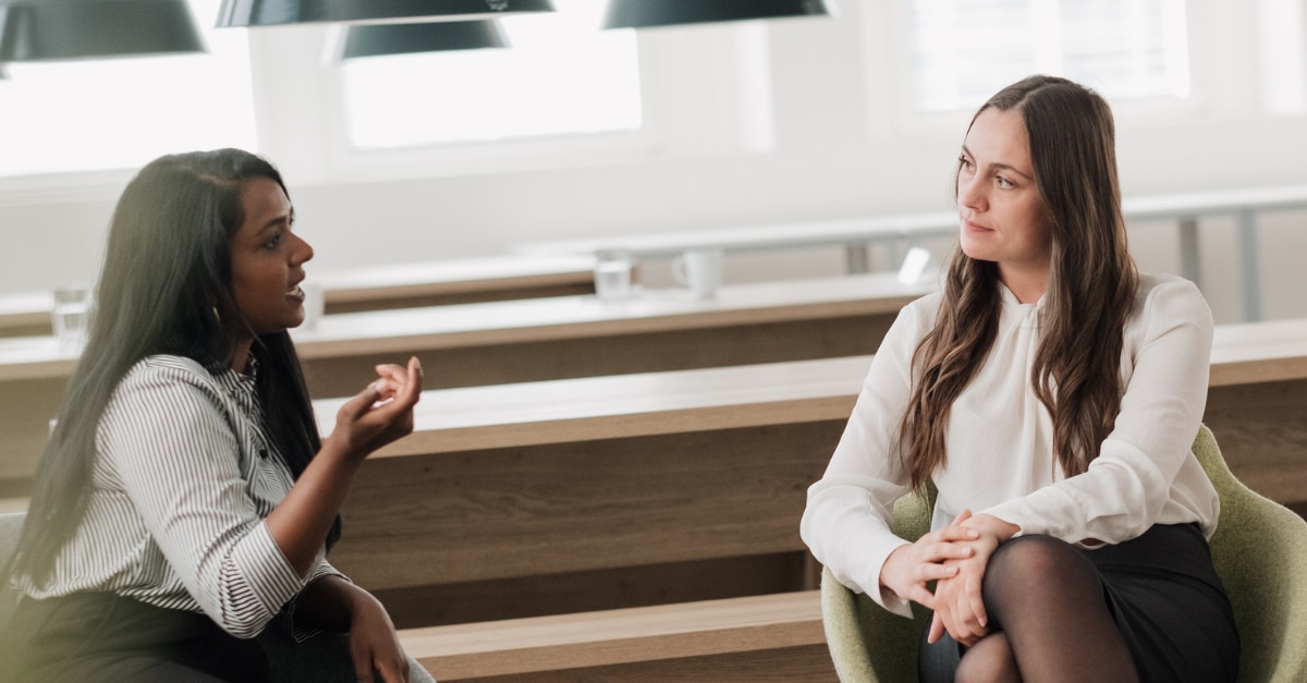Two female coworkers talking
