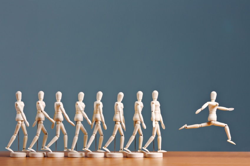 Wooden people figurines in progression from walking to leaping