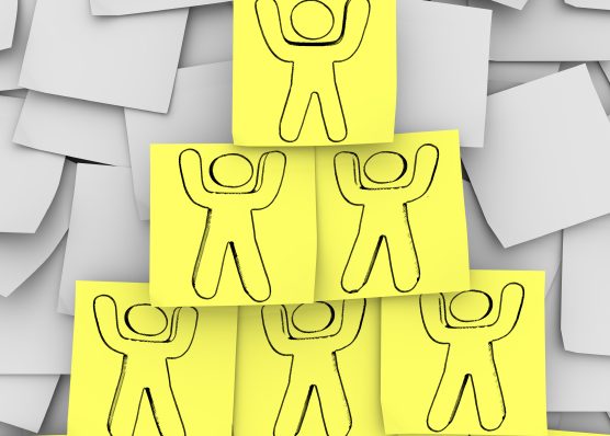 Yellow sticky notes with people drawn on them arranged in a pyramid