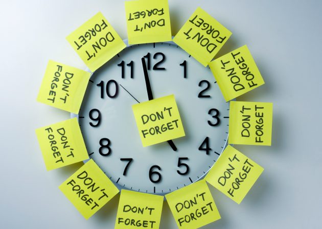 Clock covered in yellow sticky notes that say "Don't Forget"