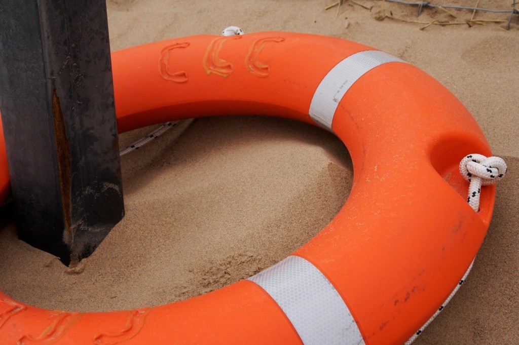 Orange and white lifesaver around a post