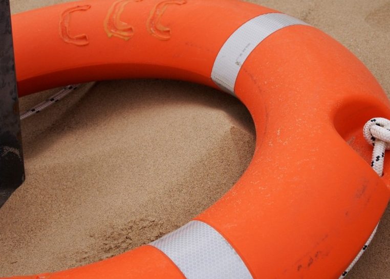 Orange and white lifesaver around a post