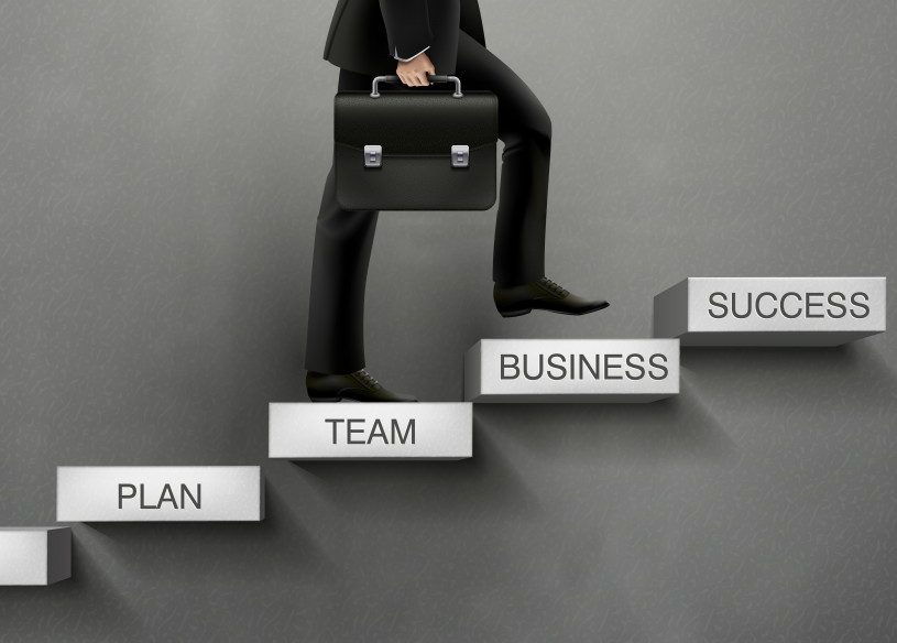 Man with brief case climbing the "ladder of success"