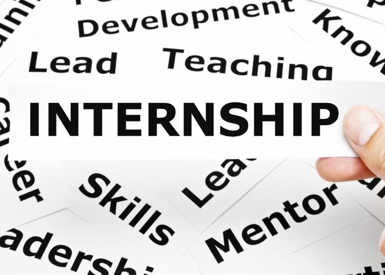 A pile of words you might find on a resume with a hand holding the piece that says "Internship"