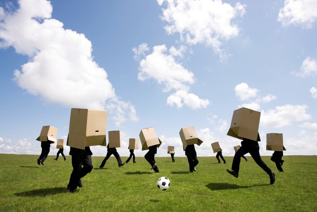 People playing soccer with cardboard boxes over their heads