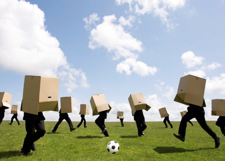 People playing soccer with cardboard boxes over their heads