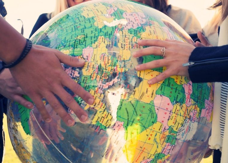 People holding a globe beach ball