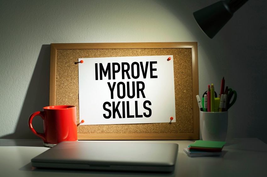 Cork board with paper that says "improve your skills"