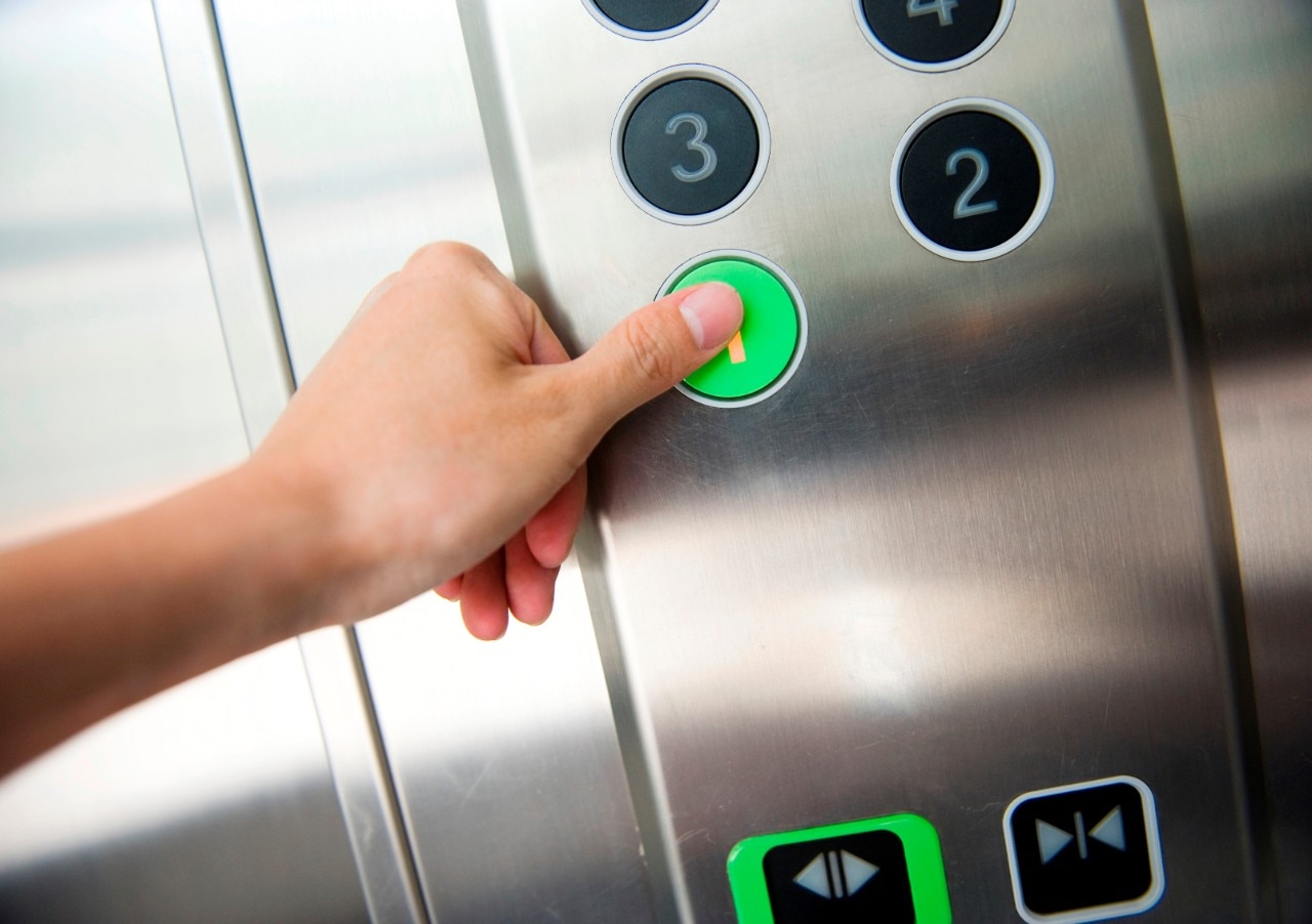 Thumb pressing the "1" button on an elevator