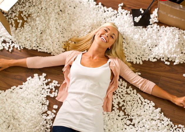 Girl making a snow angel in spilled packing peanuts