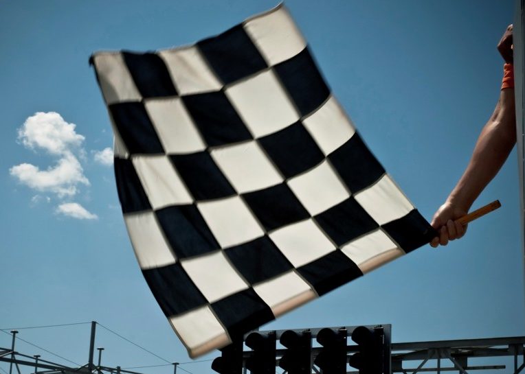 Checkered flag dropping at a racetrack