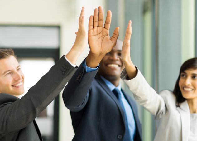 Three coworkers giving each other a high five