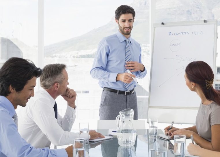 Business meeting with leader writing on white board