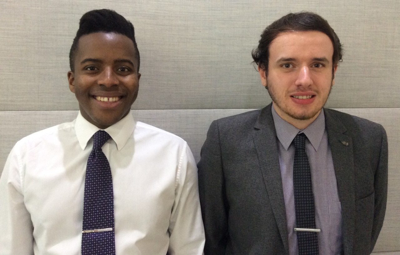 Two interns formally dressed and smiling
