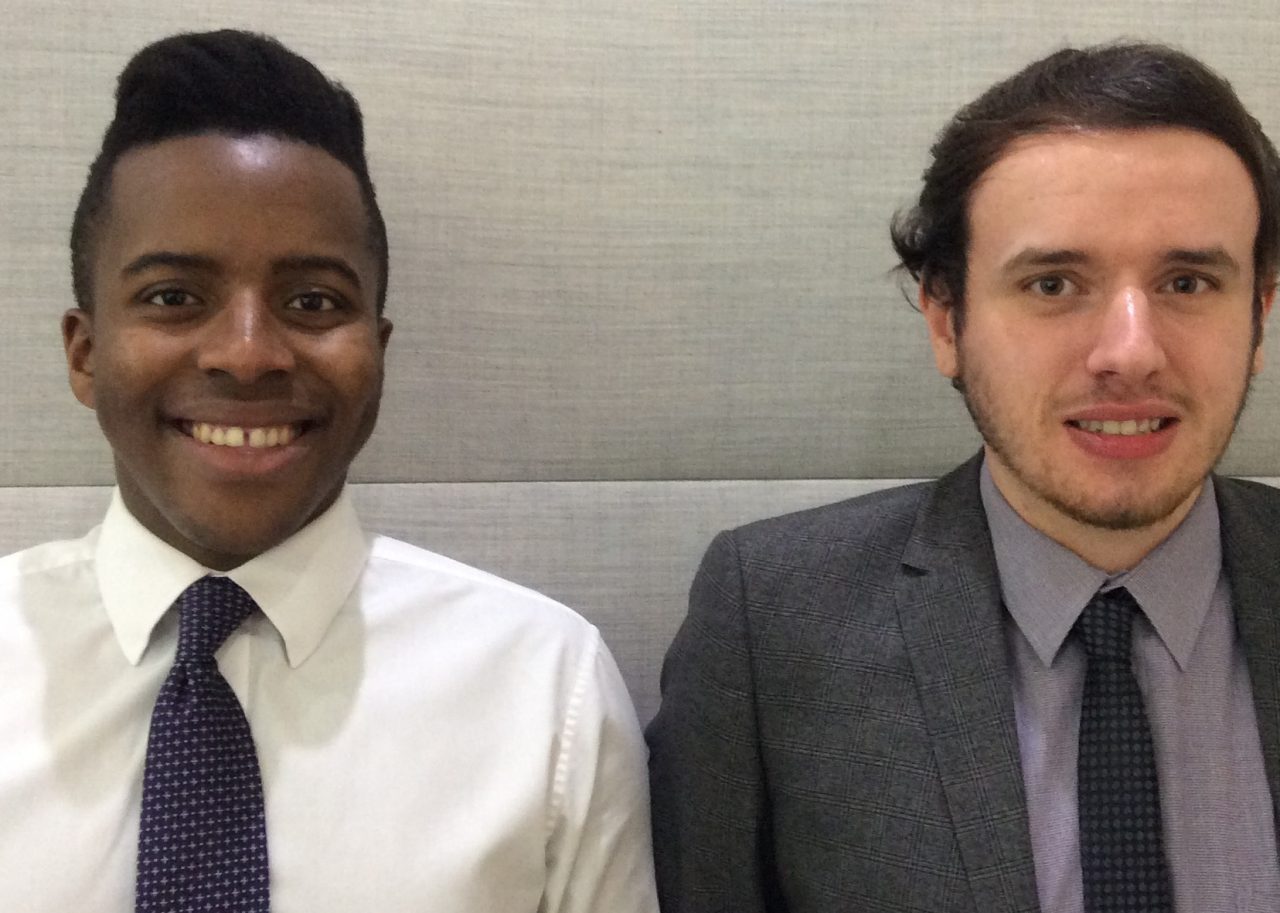Two interns formally dressed and smiling