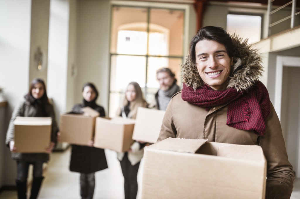 People in coats carrying boxes