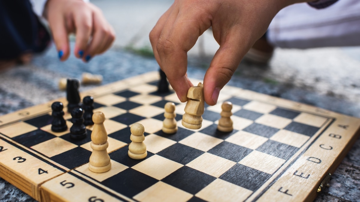 Chess board with two hands playing