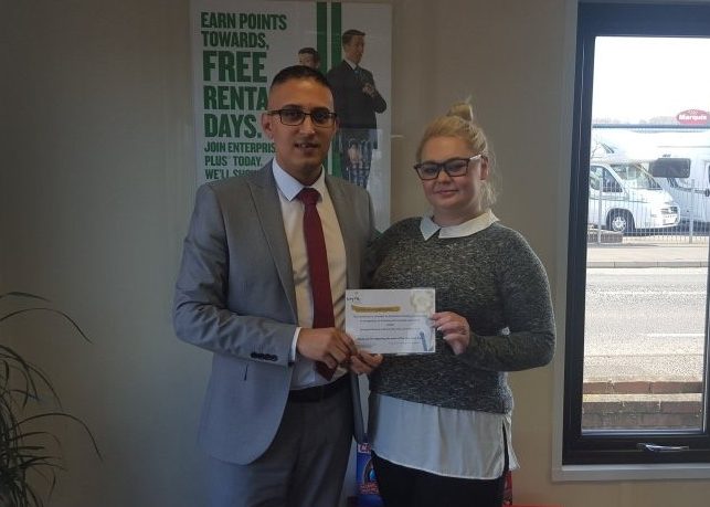 Rachael Riley receiving an award from an Enterprise employee