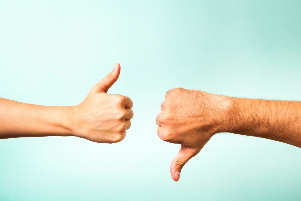 Thumbs up and thumbs down on teal background
