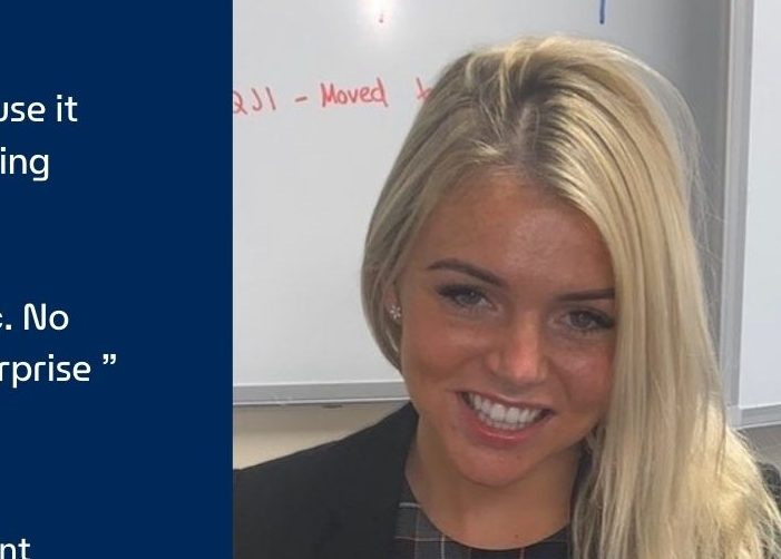 Picture of Joy in front of a whiteboard with a quote on a blue background