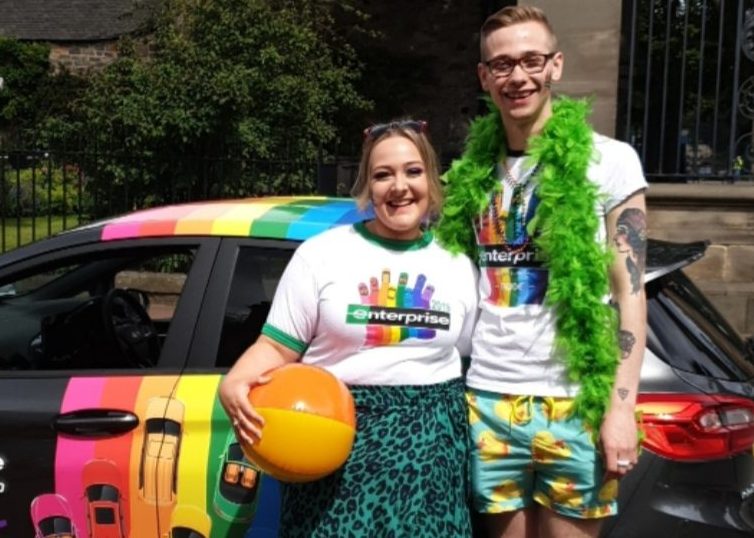 Dylan with another Enterprise employee at a PRIDE event with the Enterprise PRIDE car