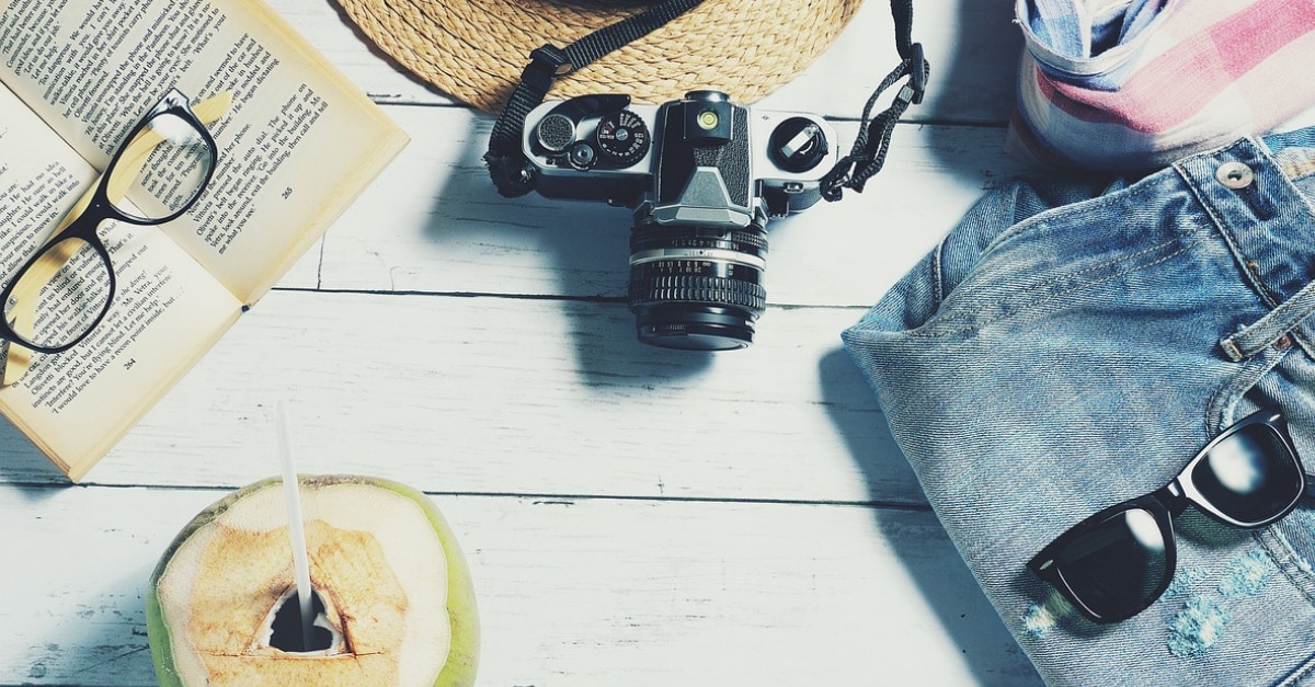 Camera, coconut, book, glasses, sunglasses, and jeans