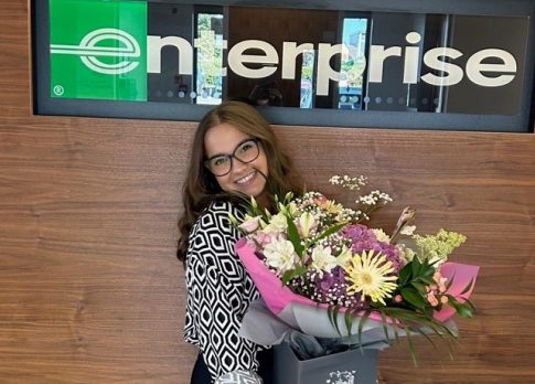 Yasmin picture with flowers in front of Enterprise sign with quote