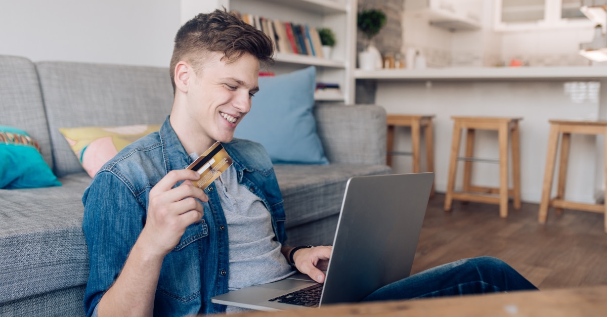 Student making money on laptop and holding a credit card